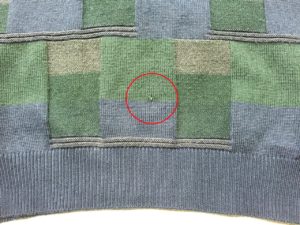 セーターの前身裾に6mmほどの穴あき